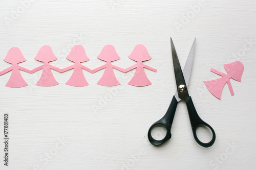 scissors have cut a paper doll from the chain photo