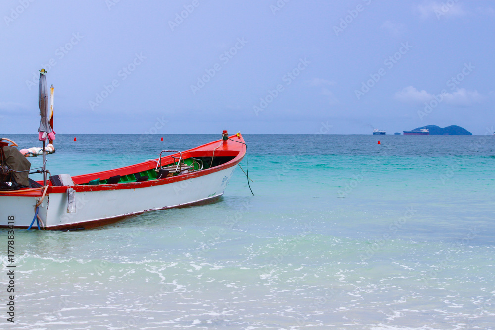 Red and white boat parked near the beach. thailand