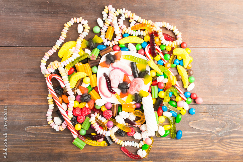 Circle of many candies over brown wooden table Circle of many candies over brown wooden table