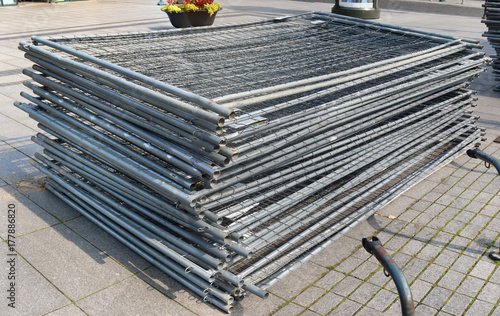 A stack of modular steel fence elements made of galvanized steel grating. photo