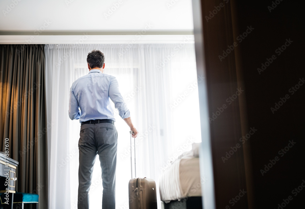 Mature businessman with smartphone in a hotel room. Mature businessman with smartphone in a hotel room.