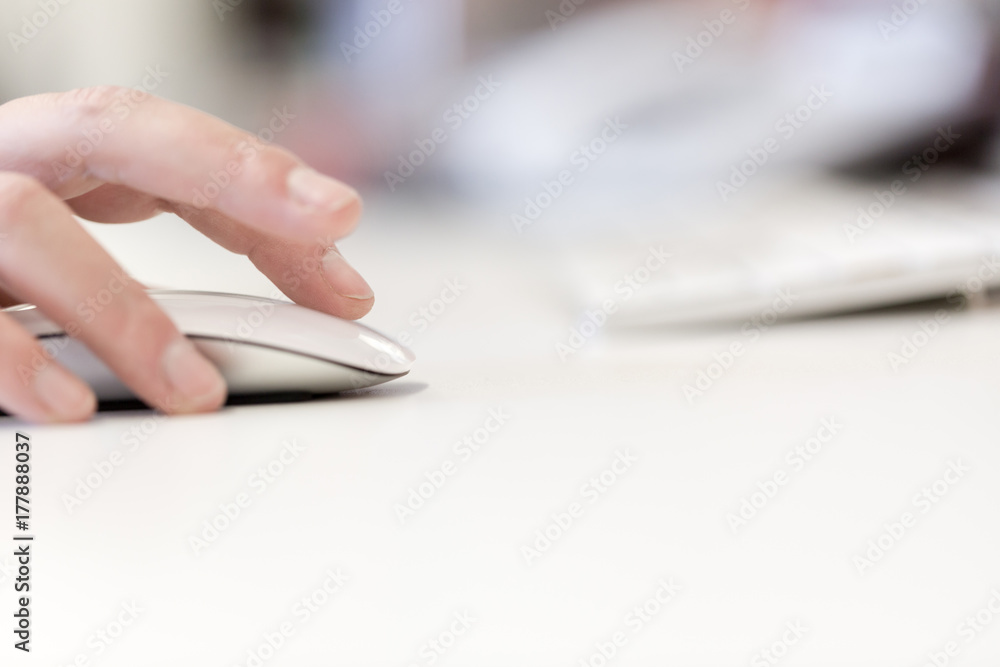 Fototapeta premium Young adult woman works on computer using mouse
