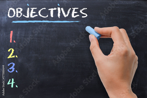 Define business or strategic objectives written by woman on chalkboard photo