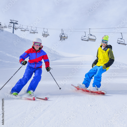 Skifahrerin und Snowboarder auf präparierter Piste