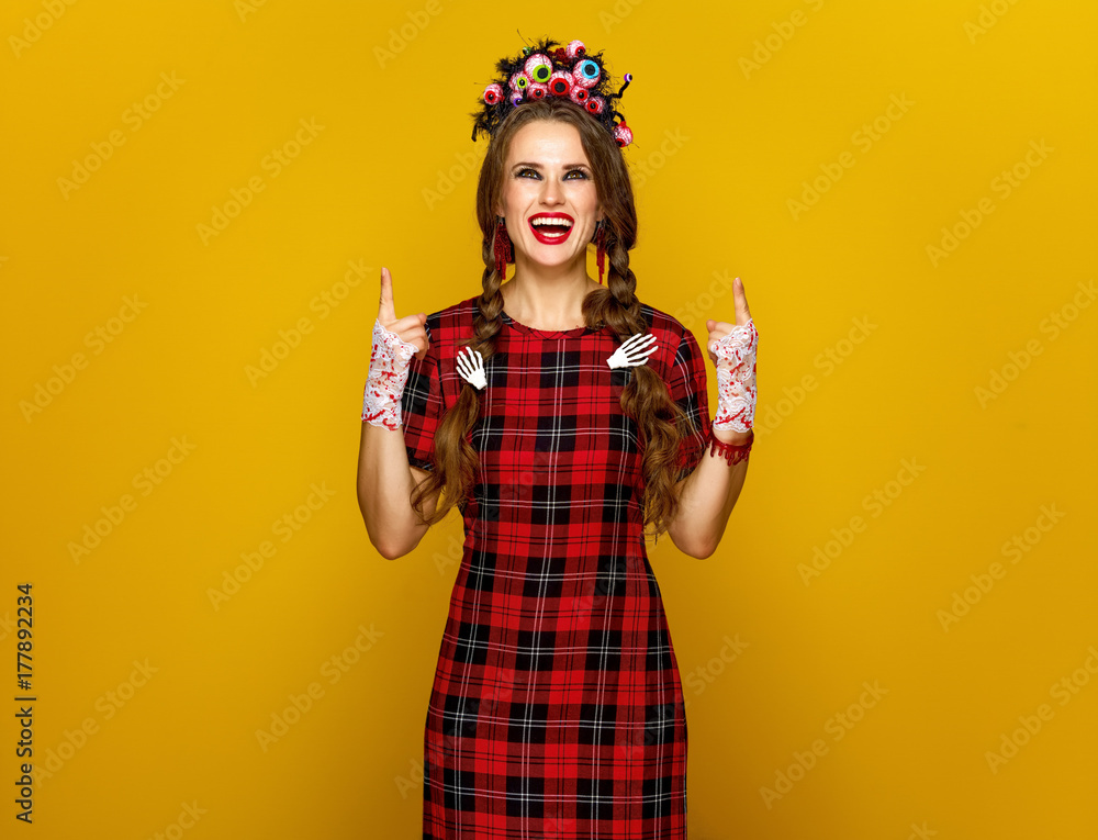 smiling woman in halloween costume pointing up at something smiling woman in halloween costume pointing up at something