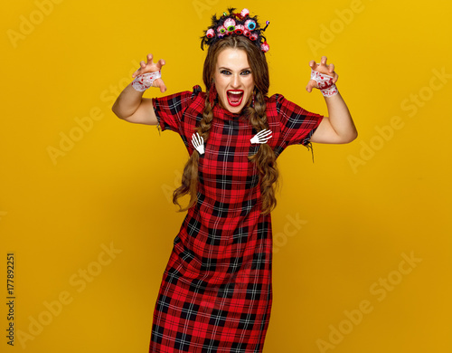 young woman in halloween costume frightening