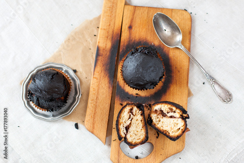Obraz na płótnie burned muffins - black cupcakes, failed baking, catastrophe in the kitchen, burned on charcoal w salonie
