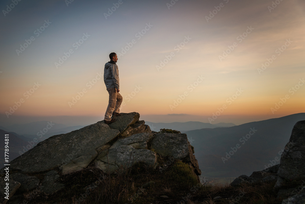 Man standing on rock on mountain top