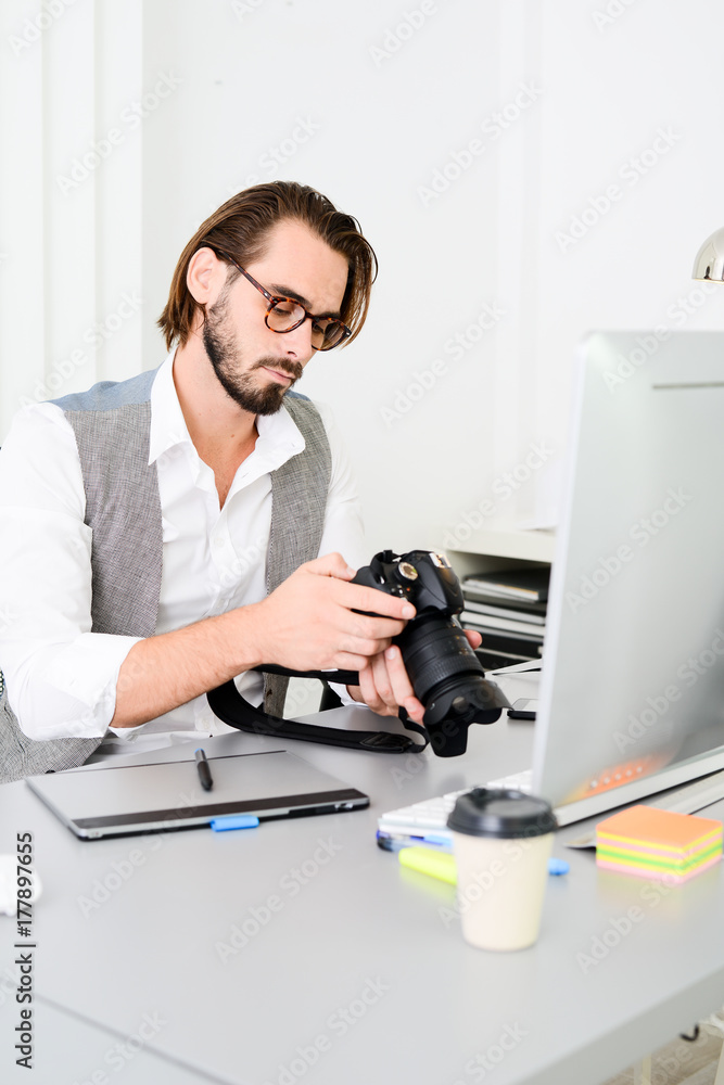 male photographer editing photography in office with a computer, camera and graphic tablet male photographer editing photography in office with a computer, camera and graphic tablet
