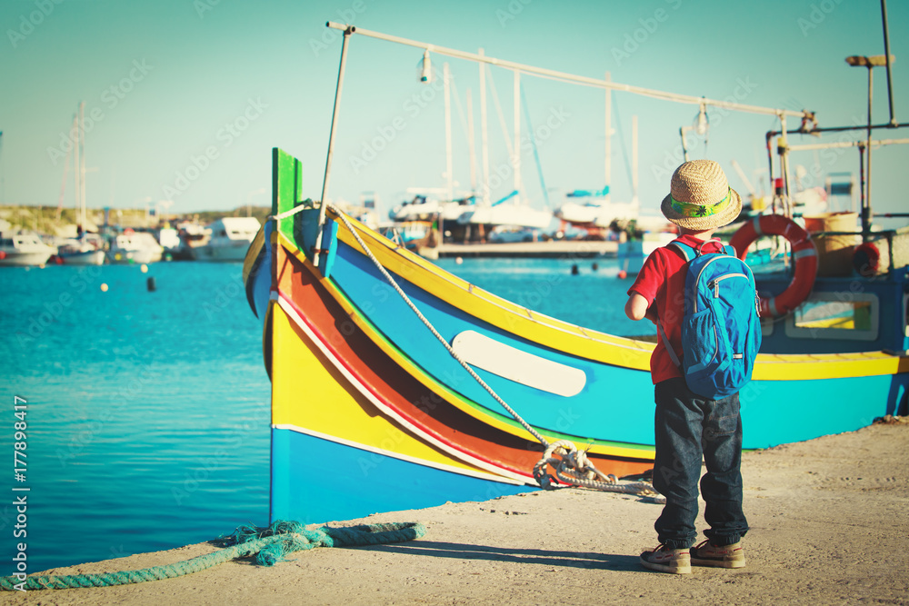 little boy looking at traditional boats in Malta