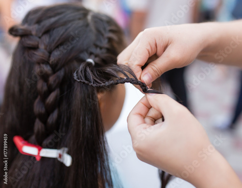 the stylist weaves the female braids on the head