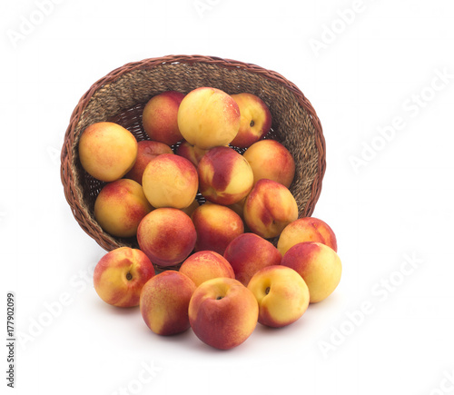 Apricots in a basket of straw on a white background