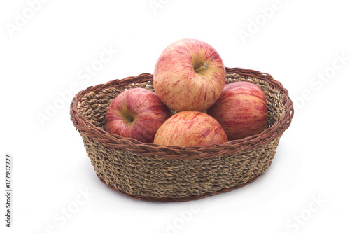 Apples in a basket of straw on a white background