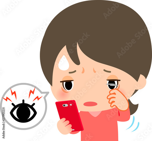 スマートフォンを見ながら目をこする女性