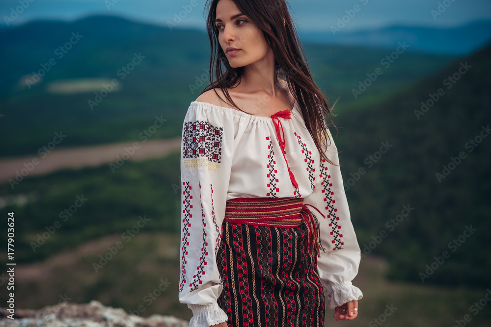 Atractive woman in traditional romanian costume on mountain green ...