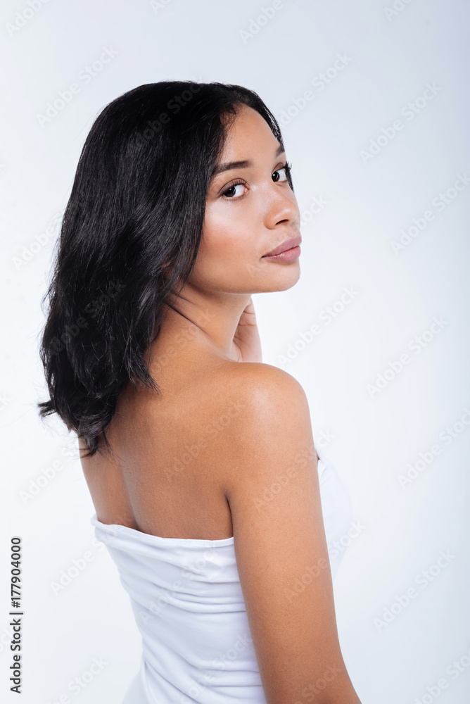 Dark-haired woman standing half-turned in off-the-shoulders top Dark-haired woman standing half-turned in off-the-shoulders top