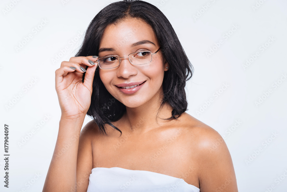 Pretty young woman adjusting eyeglasses