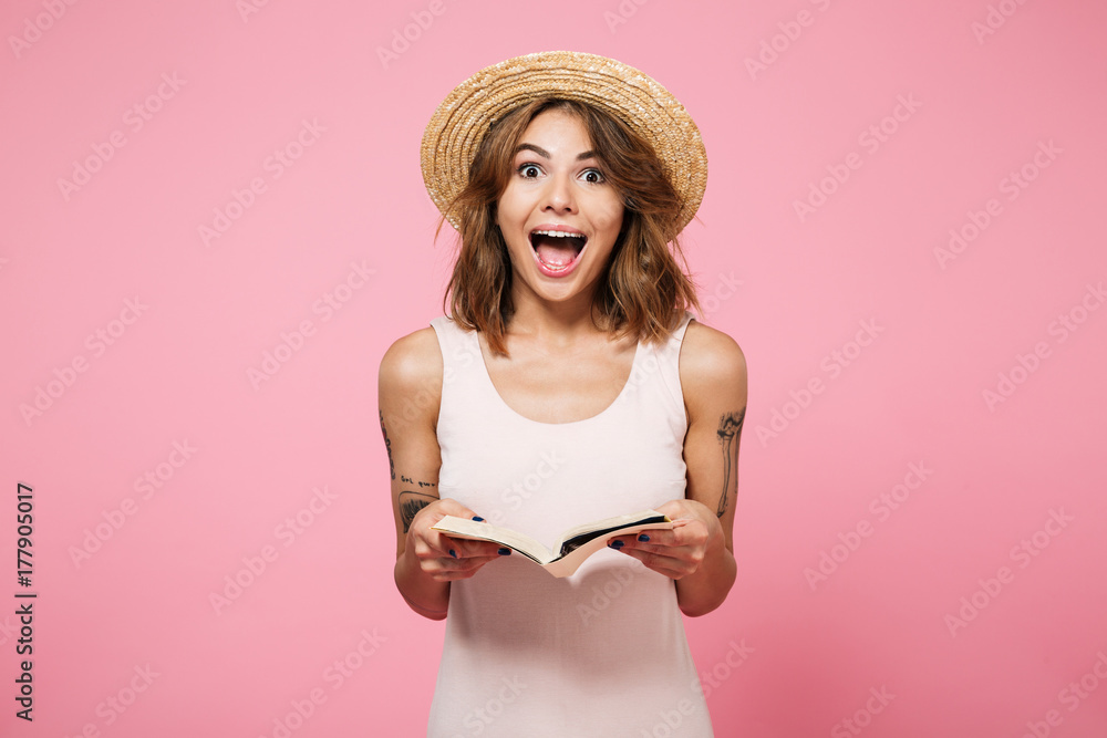 Portrait of a happy girl in summer hat holding book Portrait of a happy girl in summer hat holding book