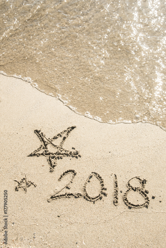 New Year 2018 is coming concept - write 2018 on a beach sand