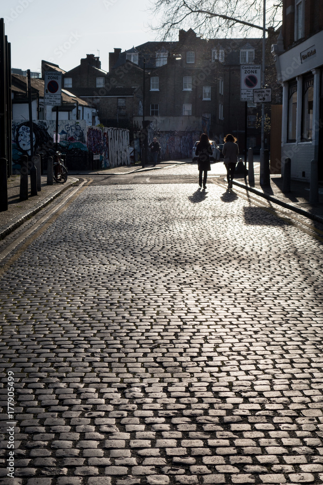 Shadows on cobbled street