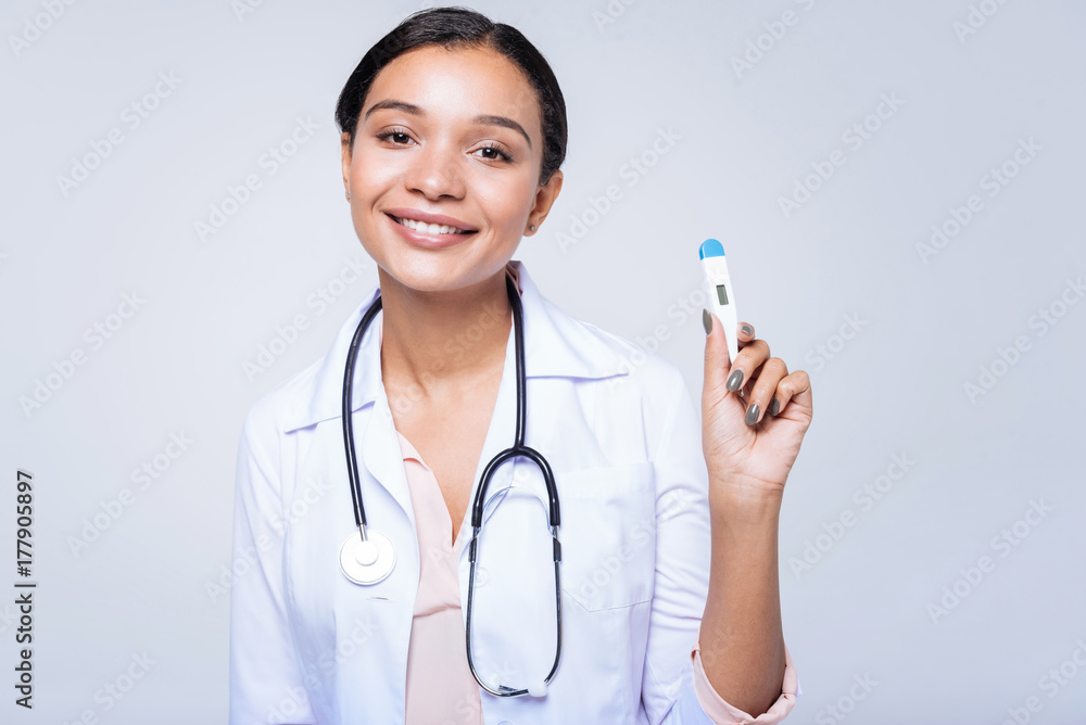Charming female doctor posing with a thermometer Charming female doctor posing with a thermometer
