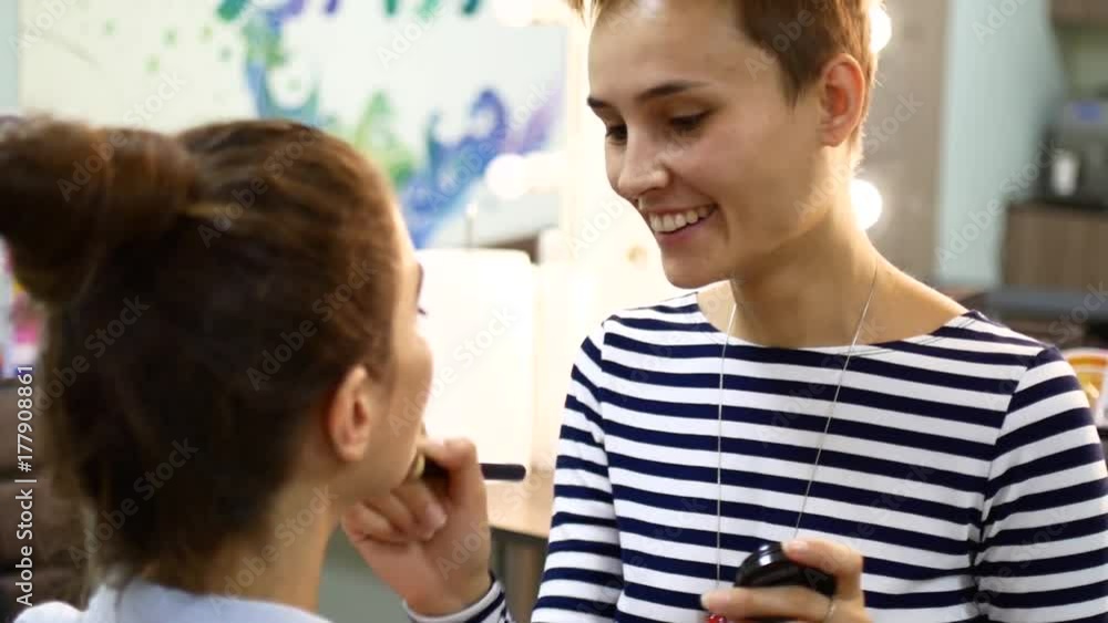 The make-up artist puts on the make-up on the client The make-up artist puts on the make-up on the client