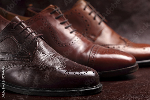 Fashion classical polished men's brown oxford brogues on leather background.Selective focus