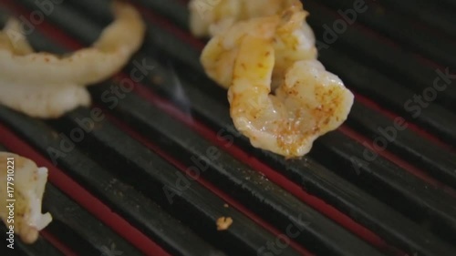 delicious prawn spit on grill with flames in background photo