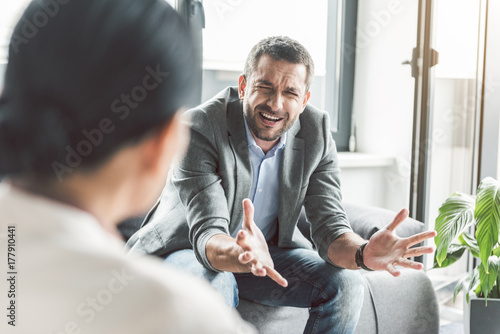 Disappointed male patient in office of psychotherapist