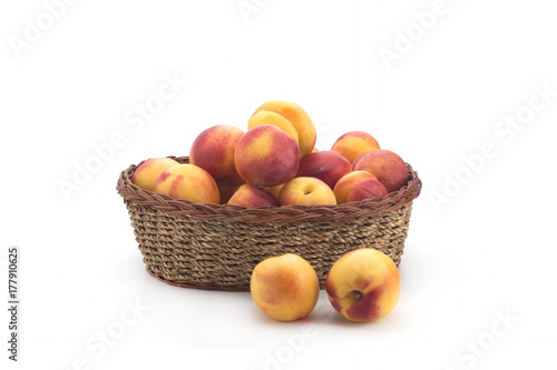 Ripe nectarines small, lying in a wicker basket