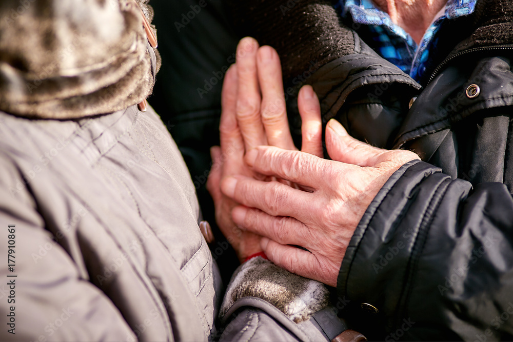 elderly people holding hands