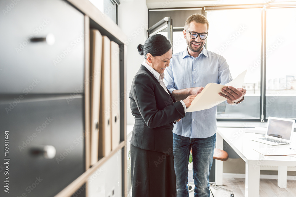 Merry colleagues having conversation in office