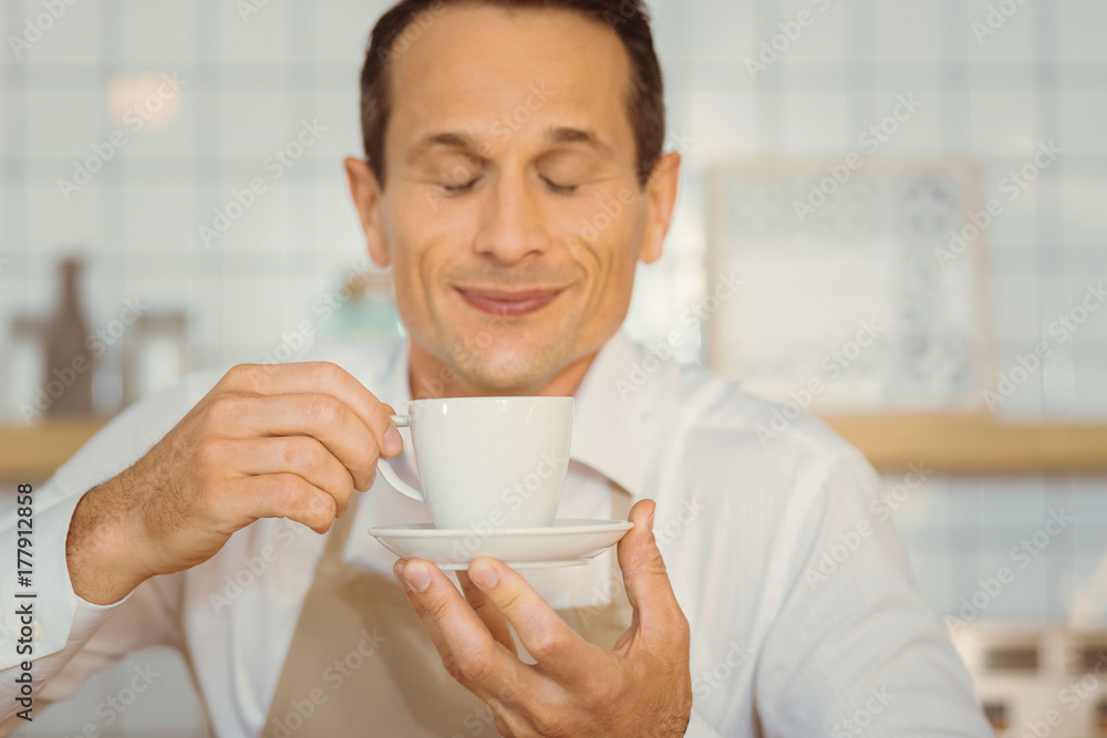 Delighted positive man tasting coffee Delighted positive man tasting coffee