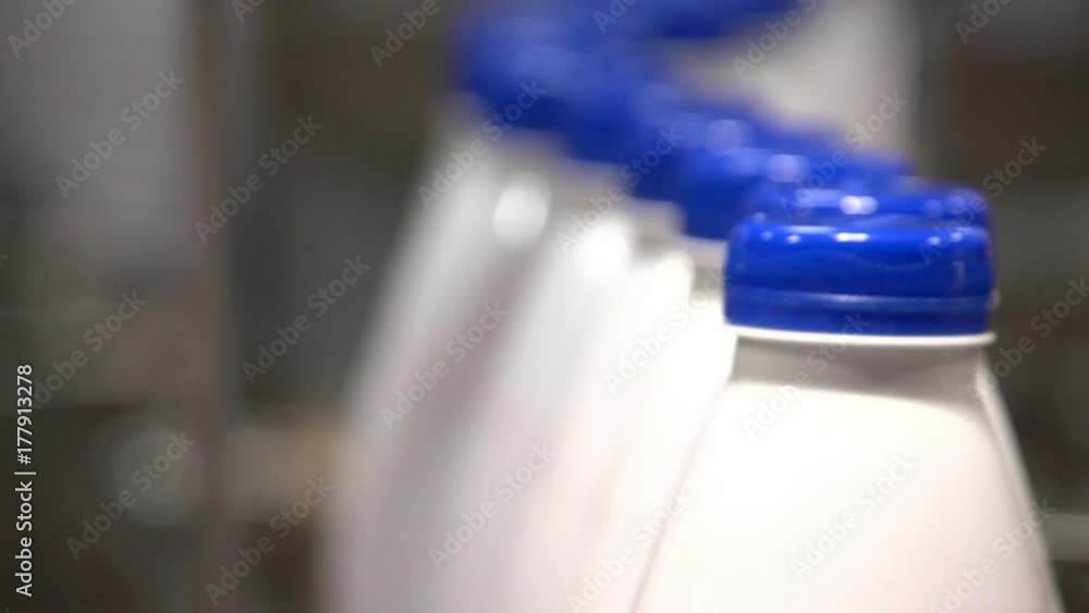 An exciting view of a working production line with milk bottles at an advanced dairy product plant in Ukraine. High-class devices and appliances operated by one machine provide high-quality products An exciting view of a working production line with milk bottles at an advanced dairy product plant in Ukraine. High-class devices and appliances operated by one machine provide high-quality products