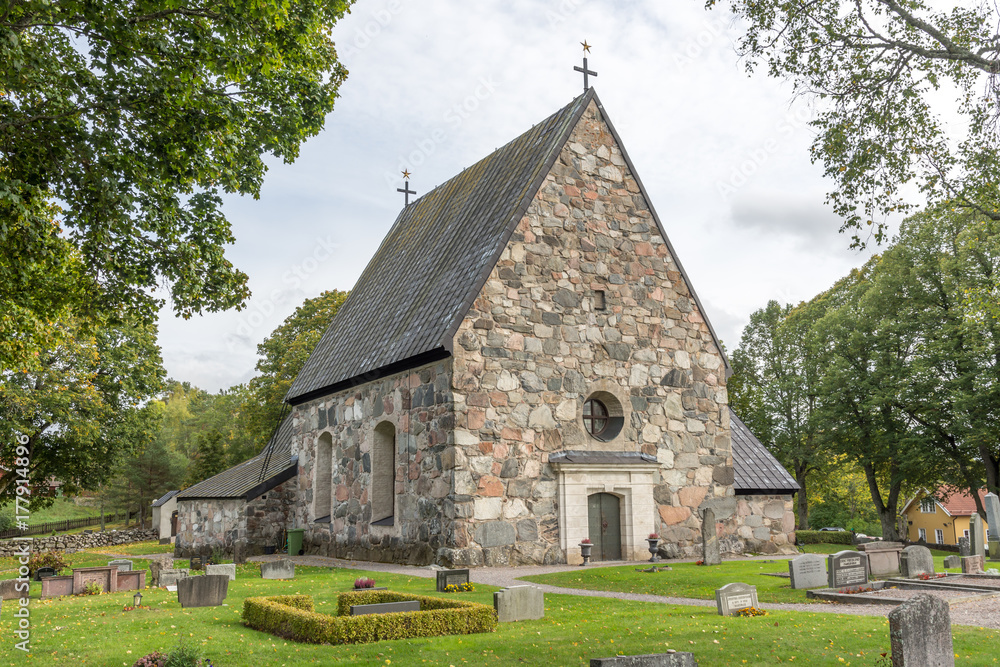 Össeby-Garns vackra stenkyrka i Roslagen sett från långsidan med huvudingången Össeby-Garns vackra stenkyrka i Roslagen sett från långsidan med huvudingången