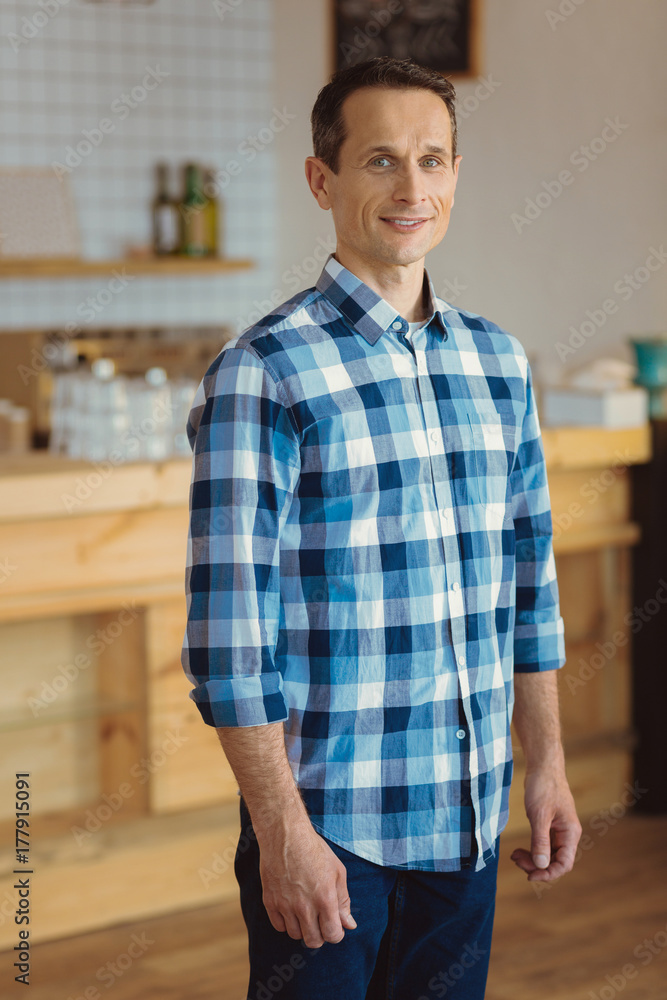 Obraz premium Pleasant good looking man standing in the kitchen