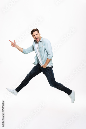 Full length portrait of a joyful happy man jumping