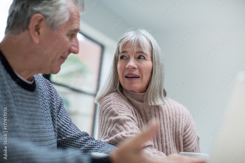 Senior couple discussing home finance together Senior couple discussing home finance together