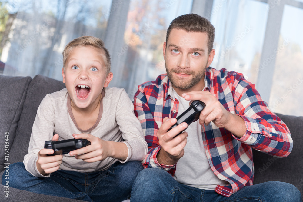 father and son playing with joysticks father and son playing with joysticks