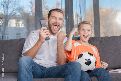 father and son watching soccer match