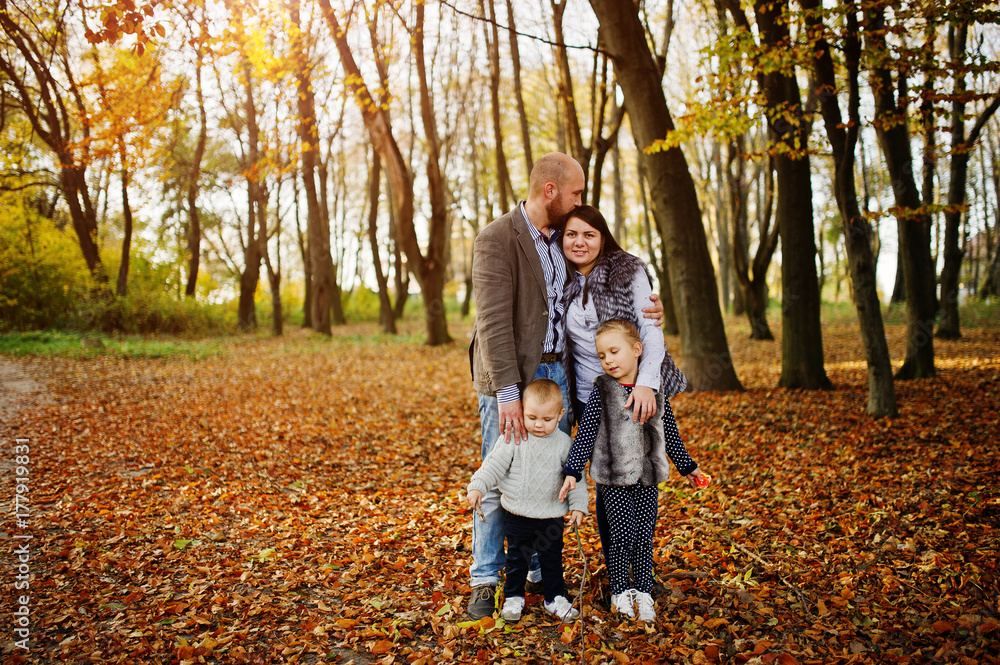 Happy caucasian family of mom dad and little girl with boy at majestic autumn fall forest. Happy caucasian family of mom dad and little girl with boy at majestic autumn fall forest.