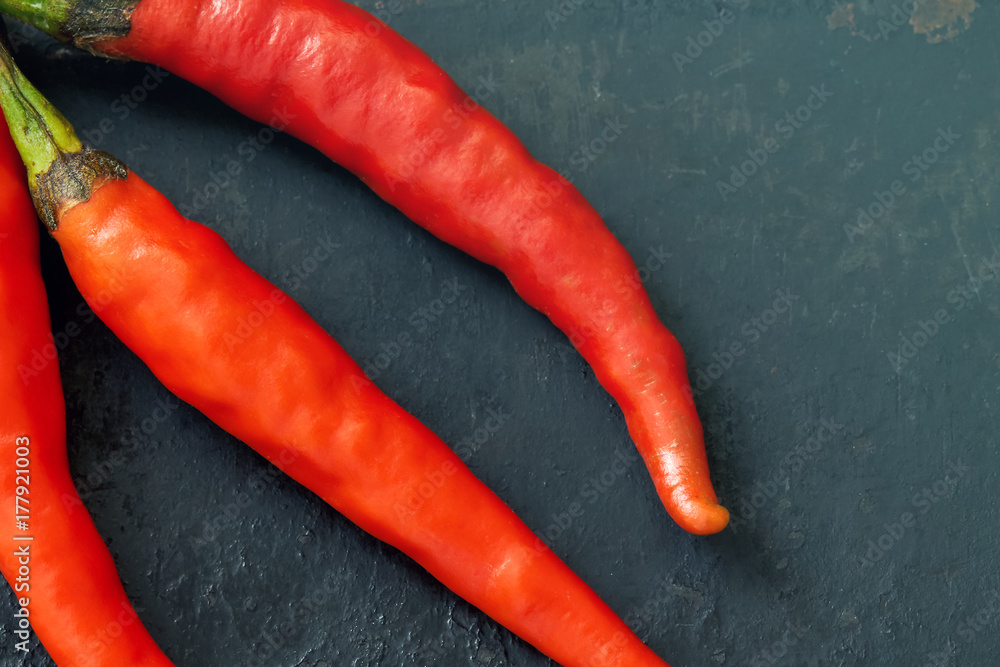 Chili peppers on black rustic background. Top view with copy space