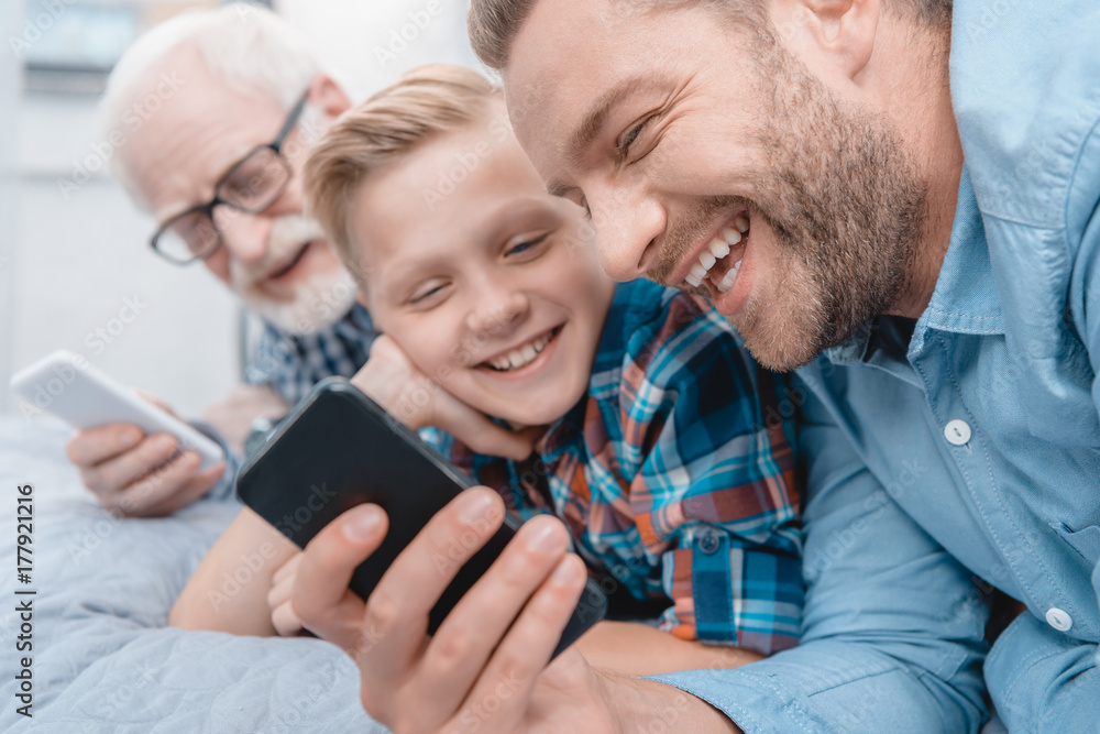 Happy family with smartphone on bed Happy family with smartphone on bed