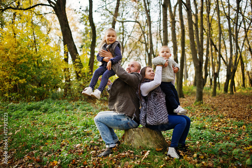 Happy caucasian family of mom dad and little girl with boy at majestic autumn fall forest. © AS Photo Family