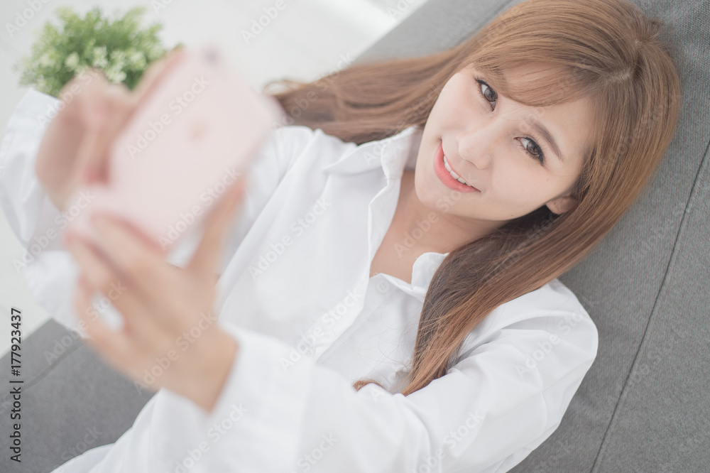 Cute girl waking up early to play mobile on the cushion,Selfie concept Cute girl waking up early to play mobile on the cushion,Selfie concept