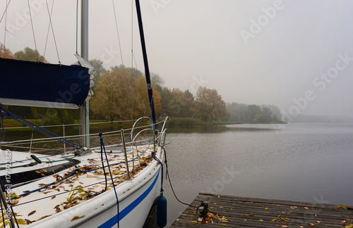 Autumn landscape with boat. Misty October morning. Autumn morning on the lake