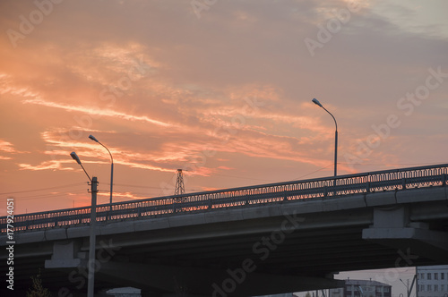 New Urengoy, YaNAO, North of Russia. September 1, 2017. Sundown and sunrises. Orange sky and much clouds. Bridge in the city street photo