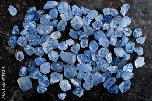 Tableau sur toile Collection of lovely blue rough and uncut sapphire gemstones on black stone slate