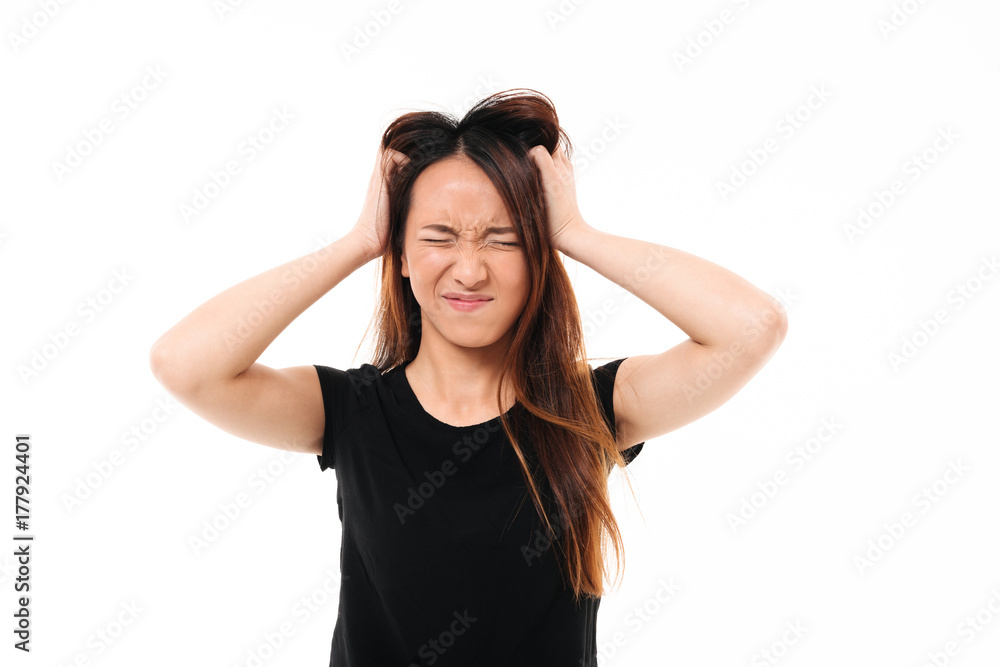 Close-up portrait of annoyed asian woman with closed eyes holding her head Close-up portrait of annoyed asian woman with closed eyes holding her head