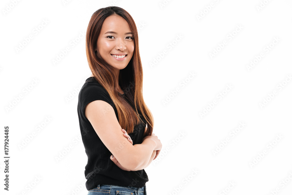 Close-up portrait of cheerful young asian woman standing with crossed hands, looking at camera Close-up portrait of cheerful young asian woman standing with crossed hands, looking at camera